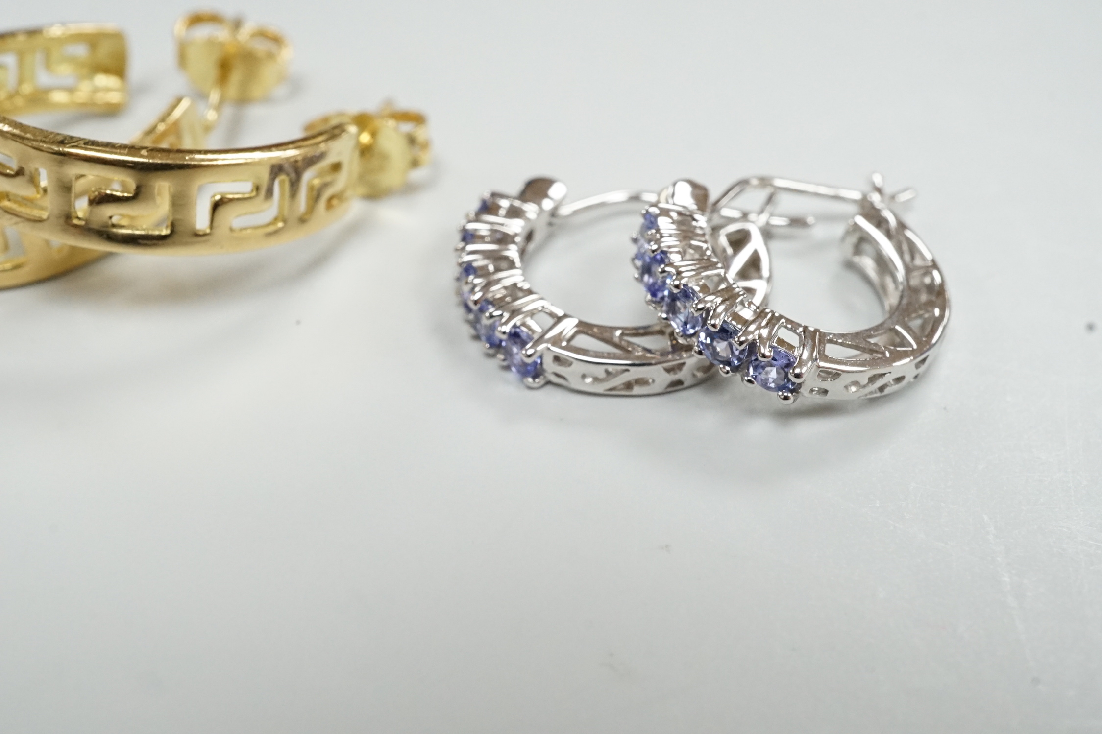 A modern pair of Middle Eastern? pierced yellow metal half hoop earrings, 23mm 6.7 grams and a modern pair of 14k white metal and gem set half hoop earrings, gross 2.5 grams.